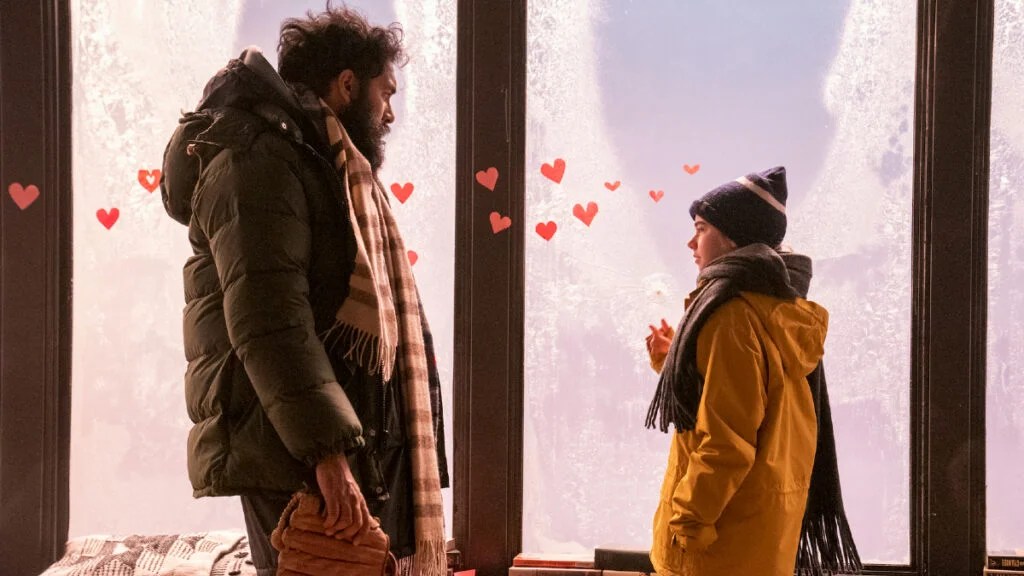 Himesh Patel and Matilda Lawler stand in front of apartment windows in "Station Eleven."